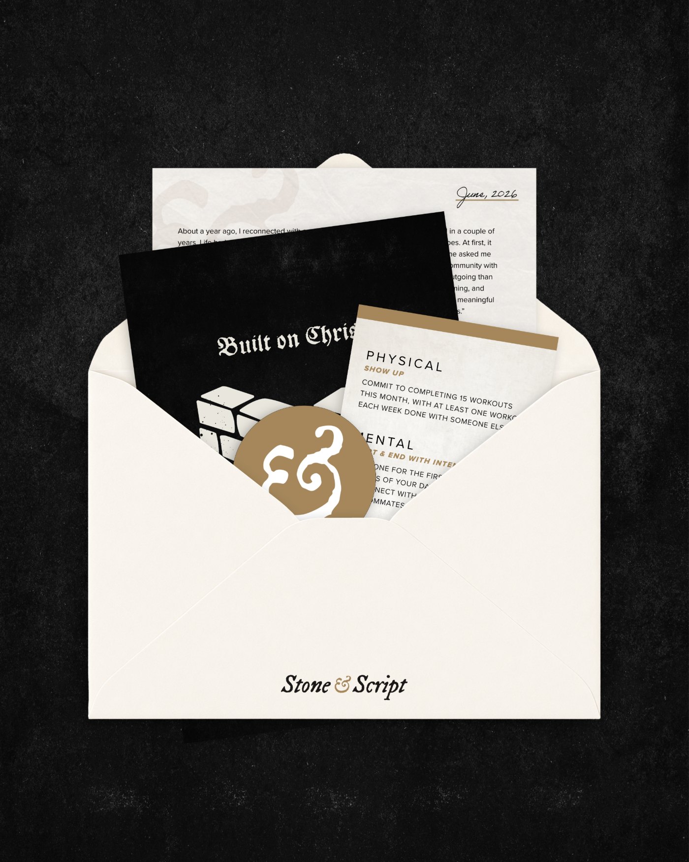 A Stone & Script envelope opened on a dark background, revealing a letter dated June 2026, a Built on Christ print, a challenge card, and an ampersand sticker.
